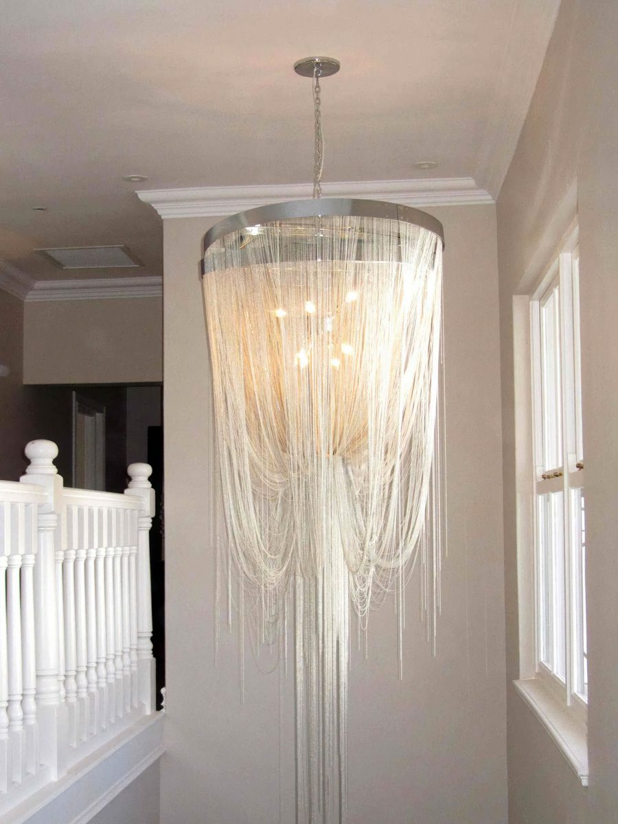 Custom chain chandelier hanging in a double-volume stairwell