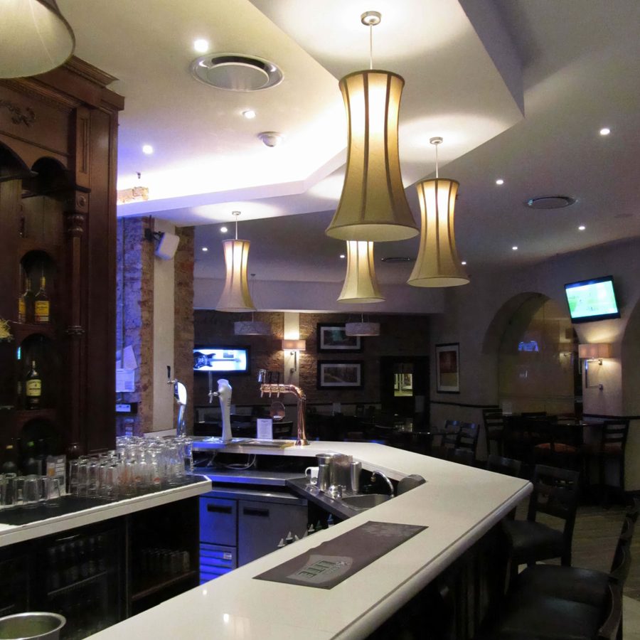Flared gold pendant shades above a restaurant bar counter