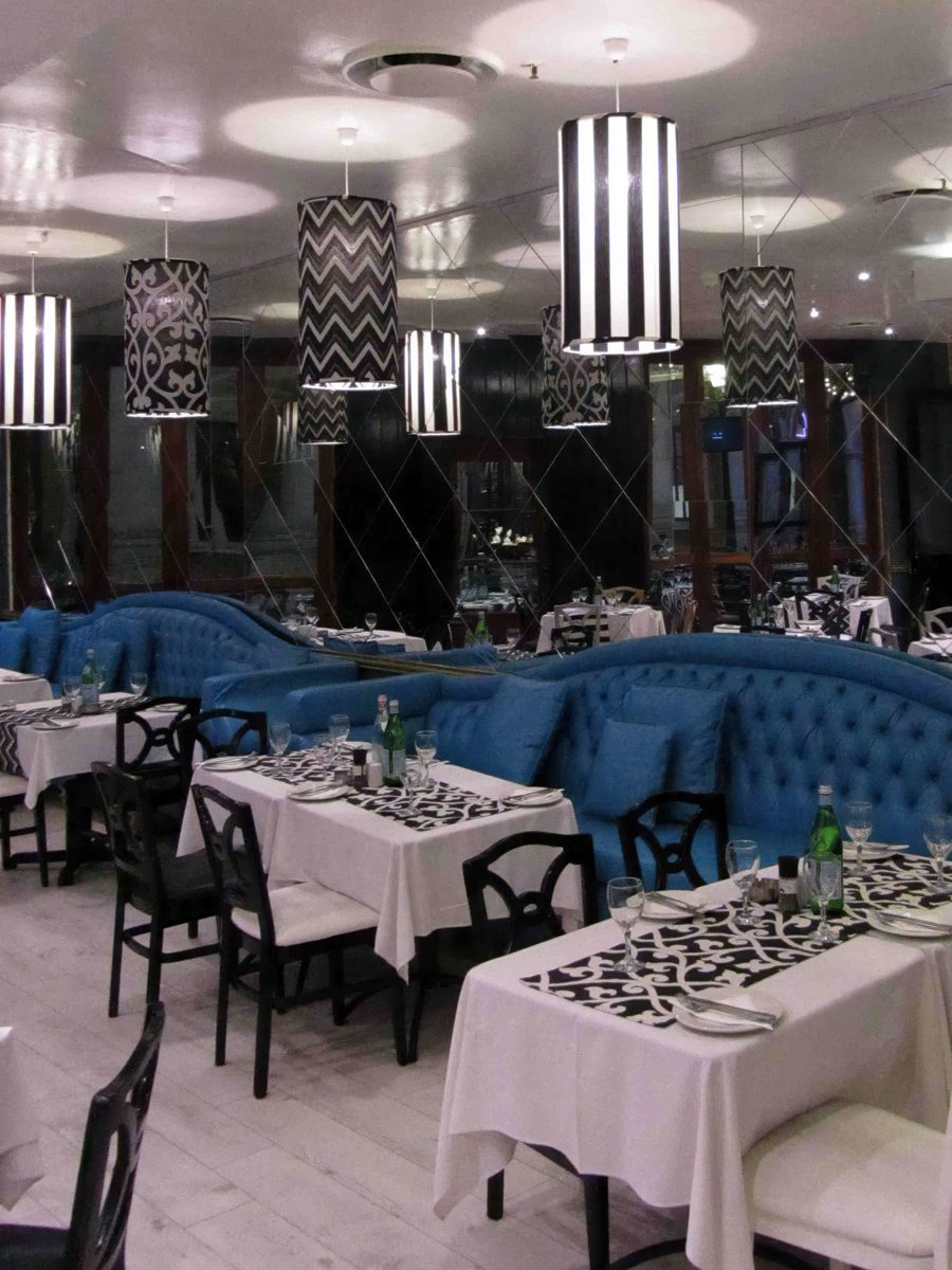 Patterned drum pendant shades above banquette seating in a restaurant